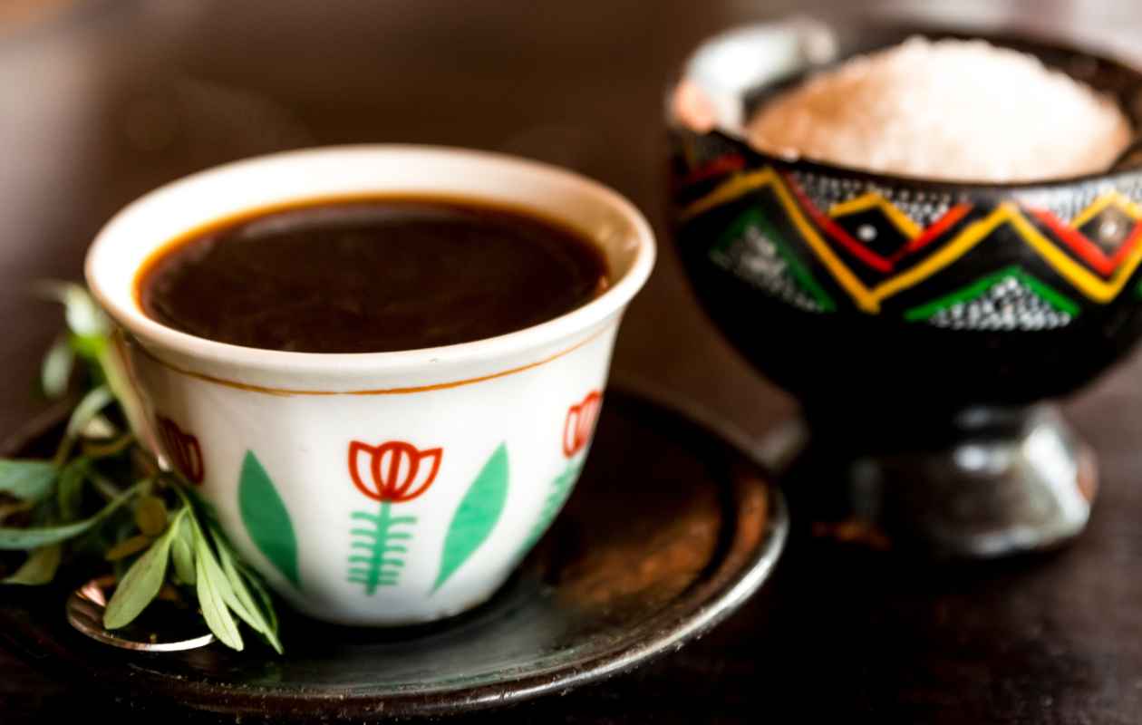 Tazas tradicionales con motivos pintados a mano llenas de café negro representando los orígenes de Etiopía - Memento Coffee