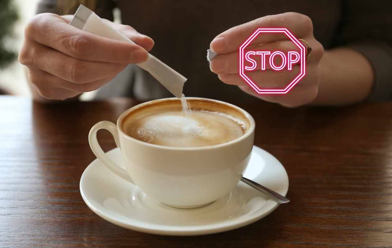 Persona añadiendo un sobre de azúcar a una taza de café expreso con un sello de stop digital superpuesto