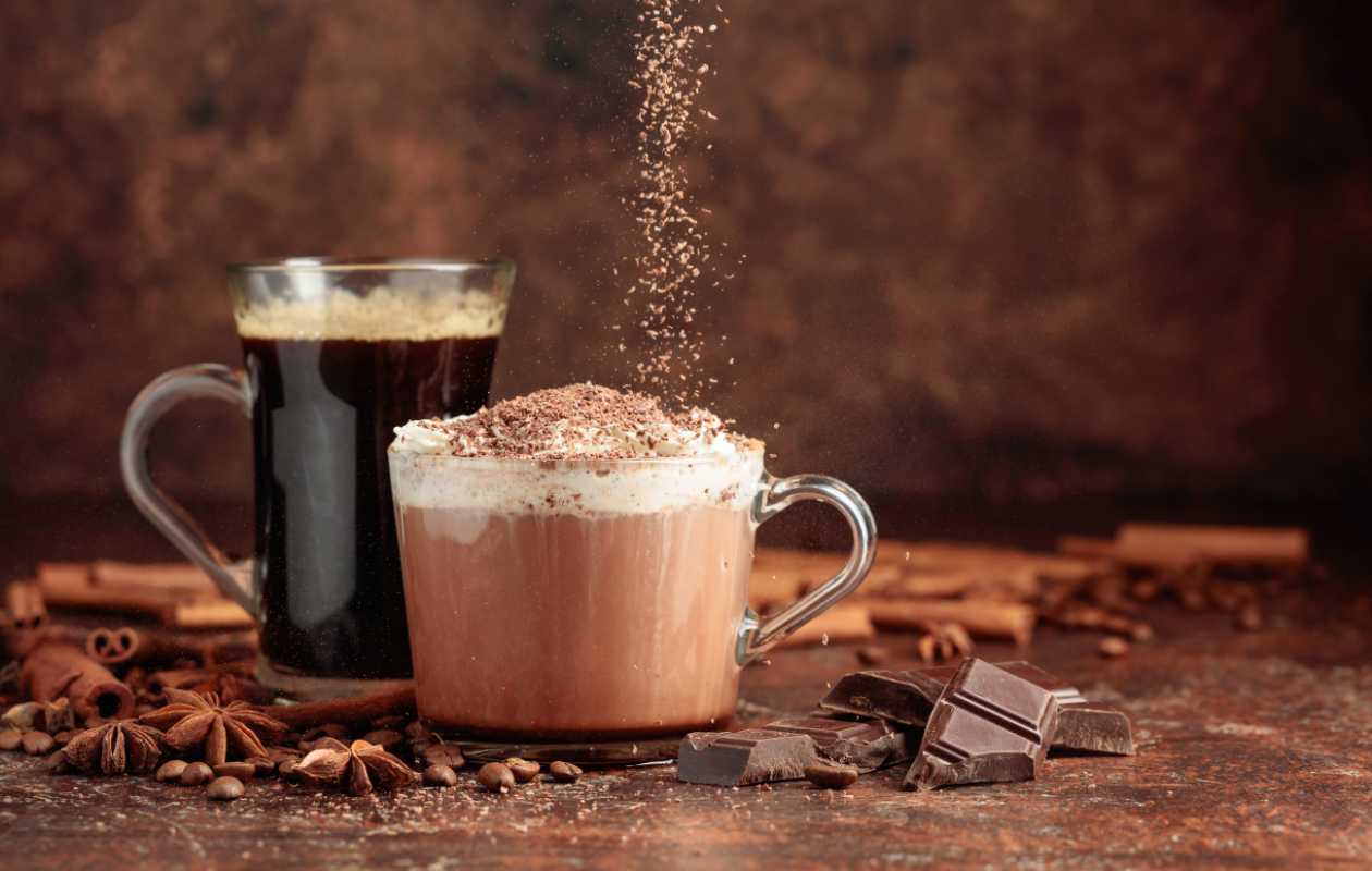 Taza de café cremoso con matices de chocolate oscuro sobre fondo rústico con trozos de cacao - Memento Coffee