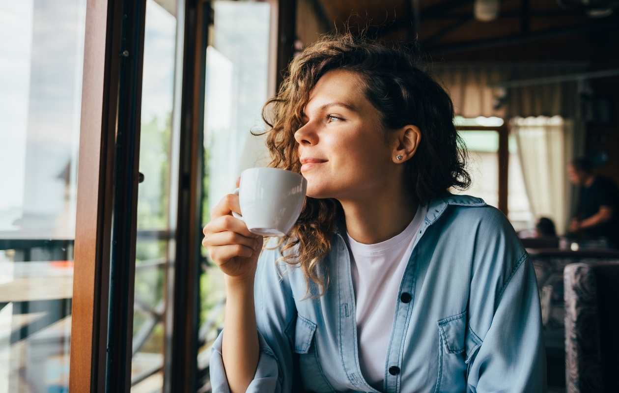 Mujer disfrutando de una taza de café de especialidad recién preparado - Memento Coffee